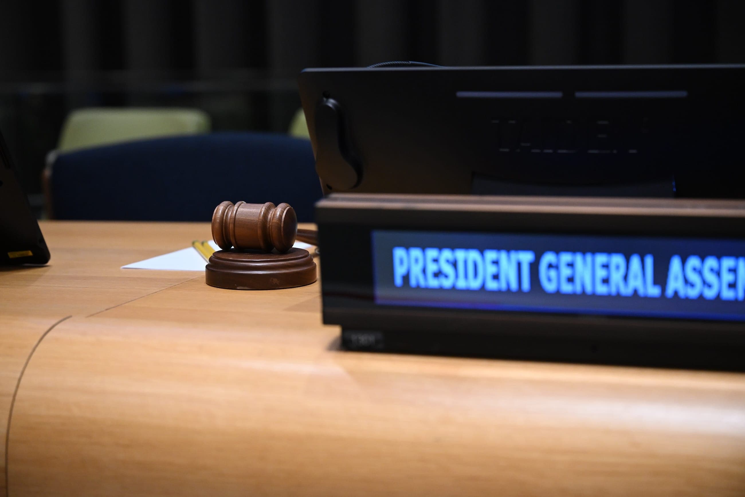 The President of the General Assembly’s gavel rests beside the illuminated desk nameplate.
