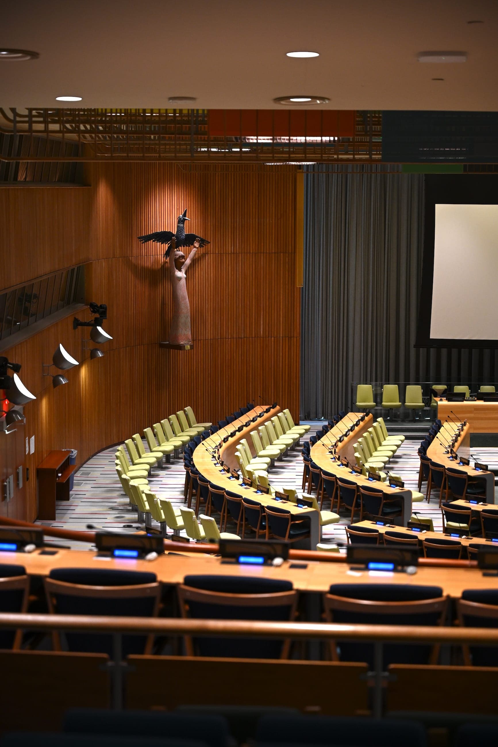 Curved rows of empty seats in a United Nations conference room.