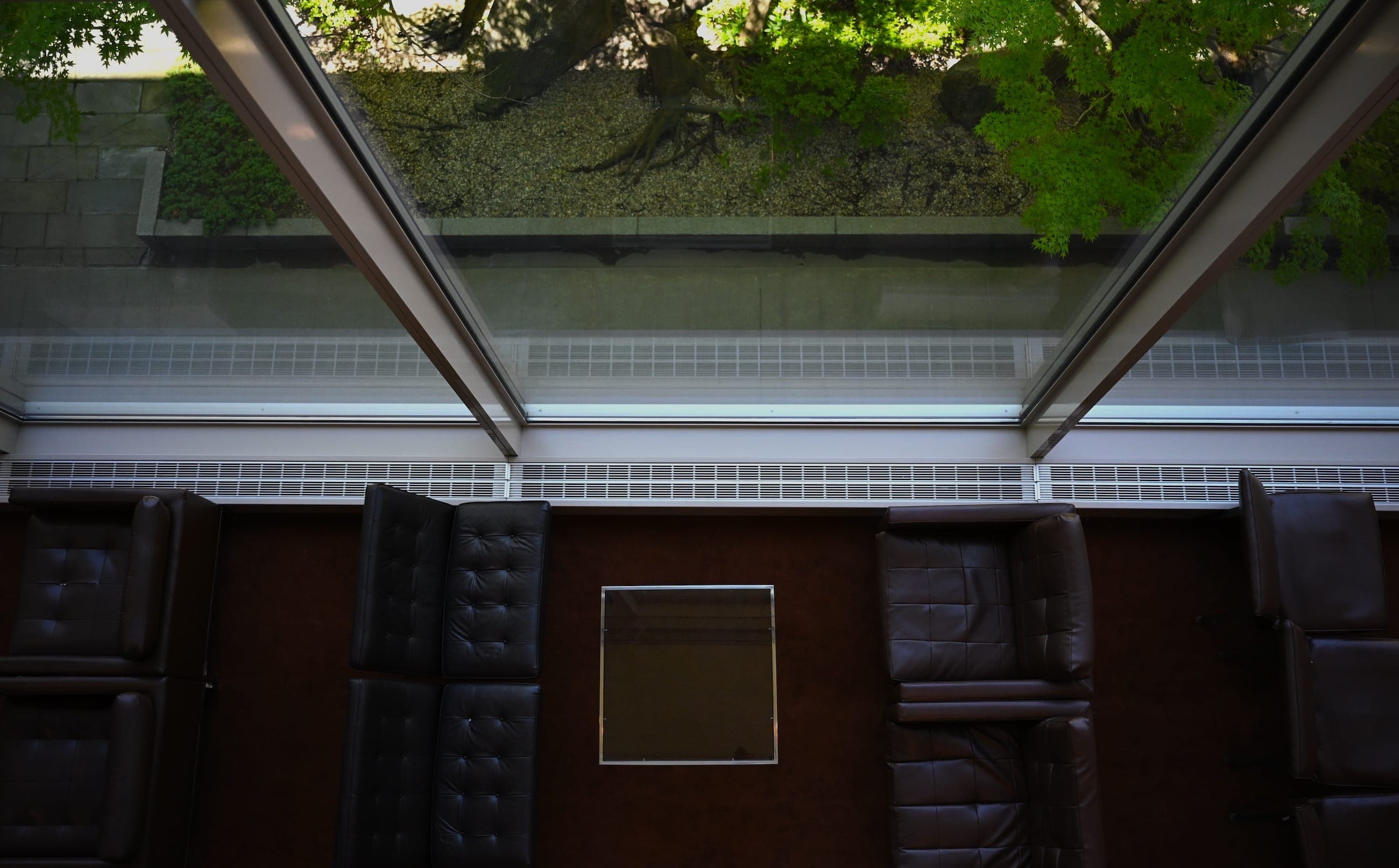 An overhead view of a conference table beside windows overlooking the United Nations garden.
