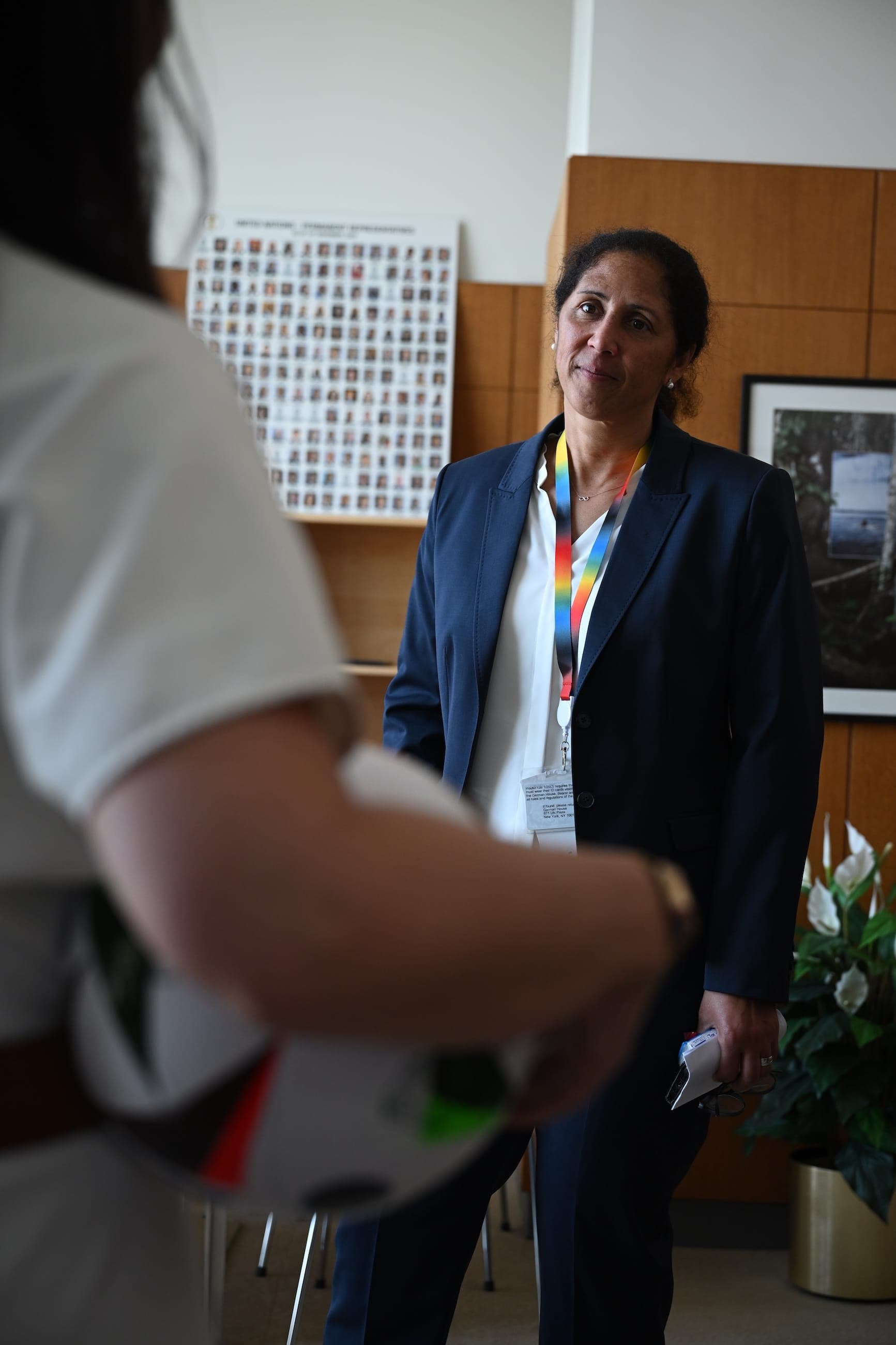A woman wearing a conference lanyard speaks during an interview in an office.