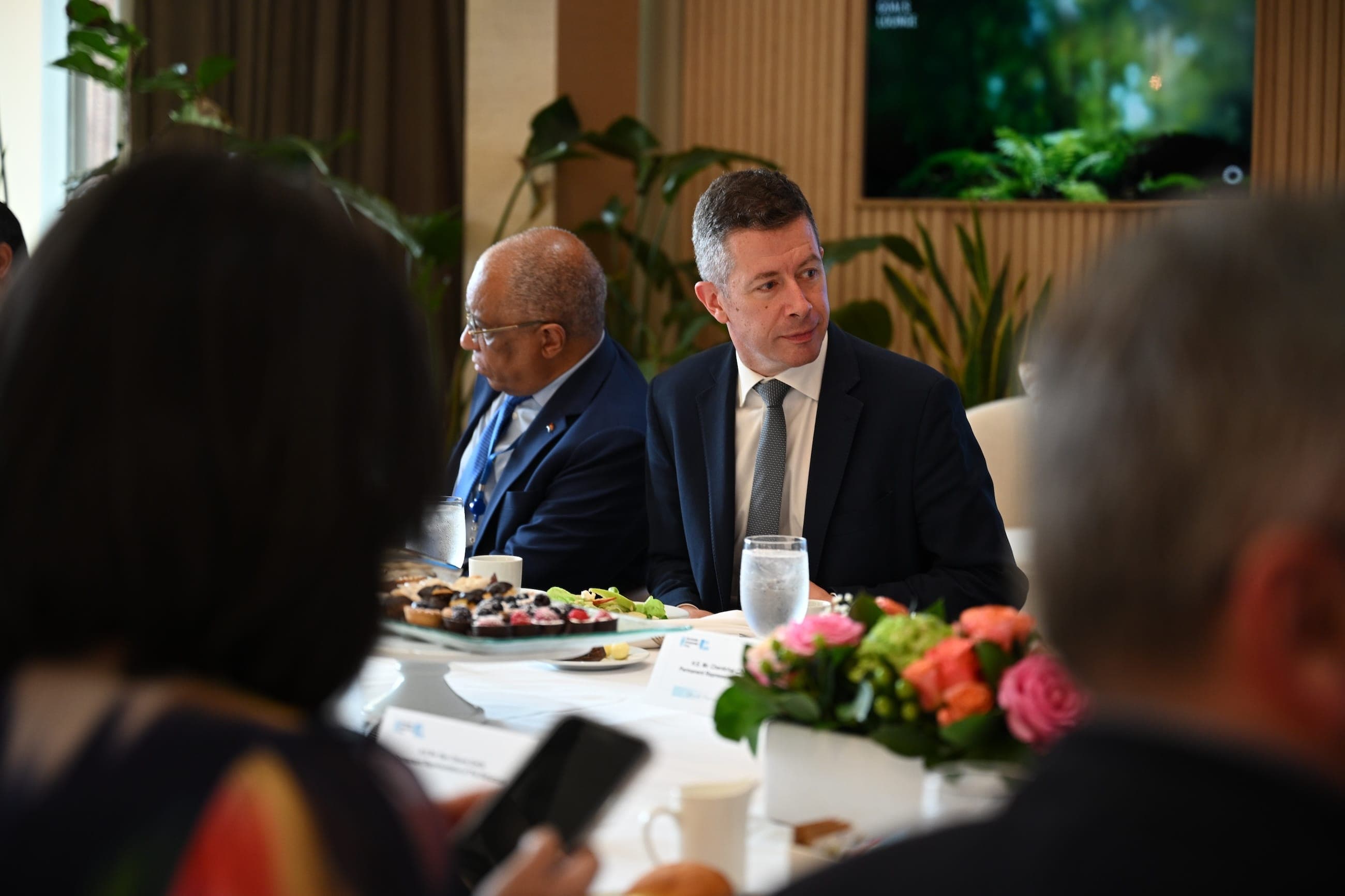 A suited delegate listens during a round-table lunch in the United Nations Goals Lounge.
