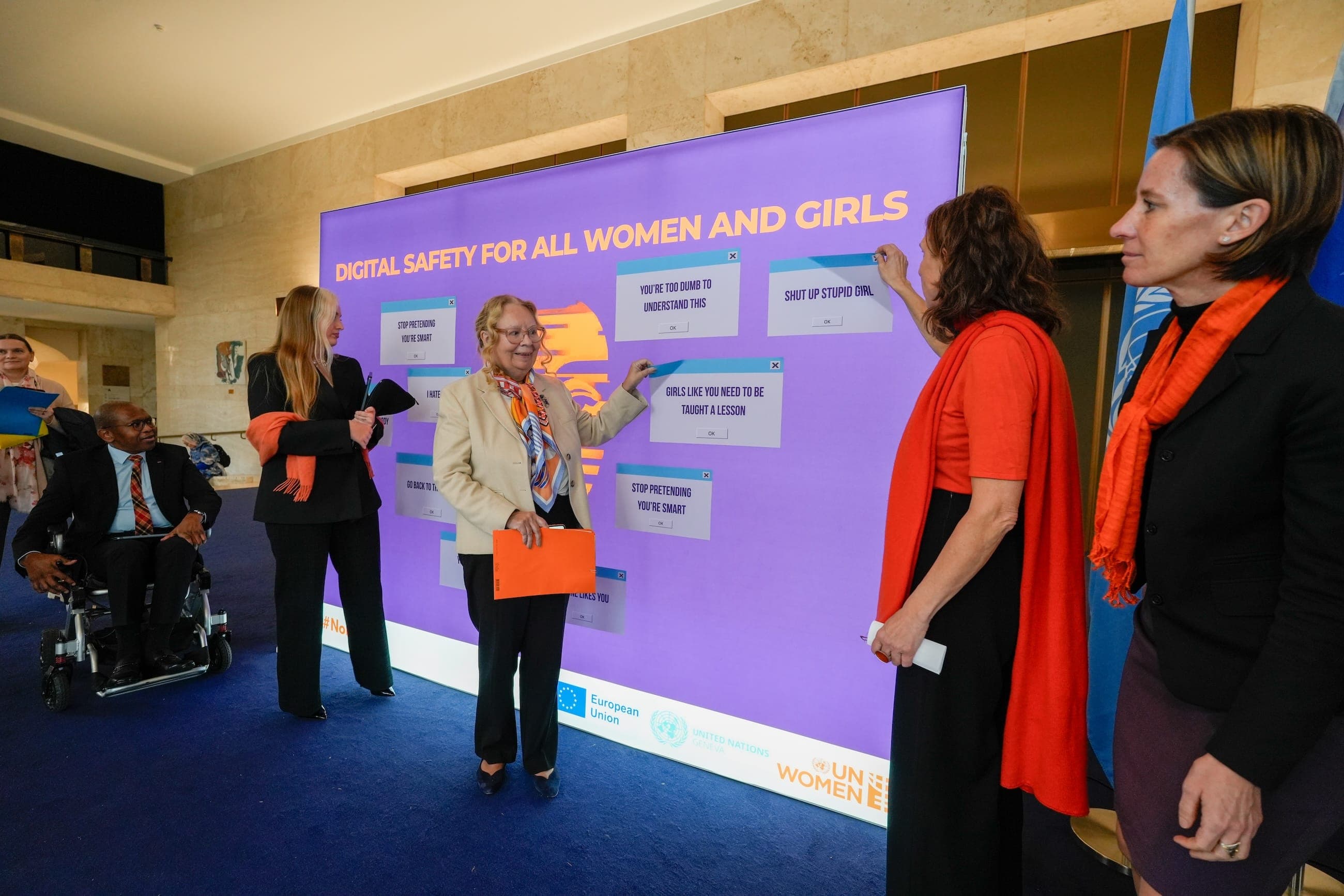 Speakers remove abusive message cards from the digital safety installation during the event.
