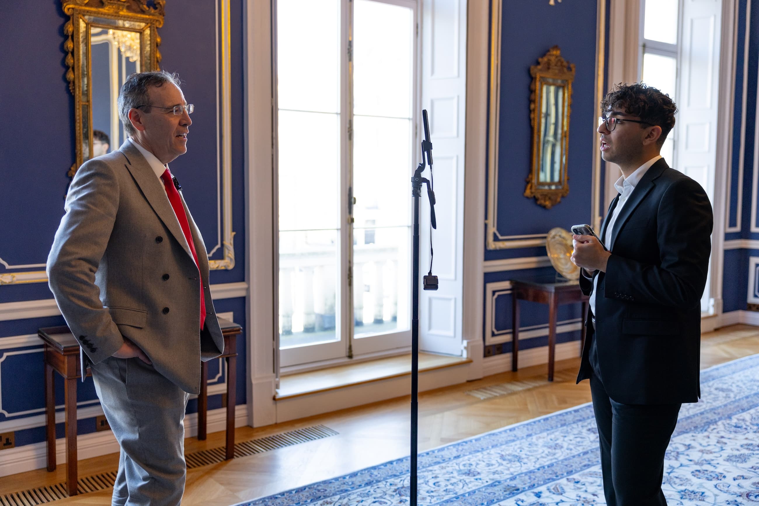 Emirhan Dalci interviewing a symposium speaker using a smartphone recording setup